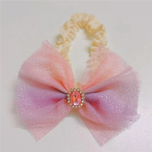 Detail of pink gradient mesh bow headband with central rhinestone and lace band