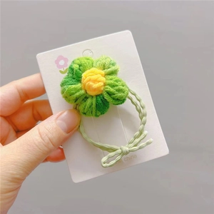 Handgefertigtes gehäkeltes Blumenhaargummi mit gelben Blüten und grünem Gummiband