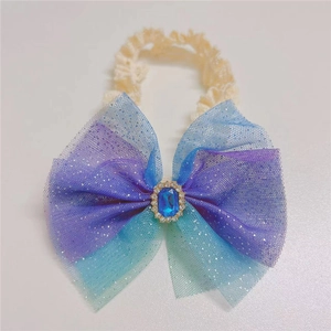 Close-up of baby lace headband featuring a gradient mesh bow with blue gemstone and rhinestones