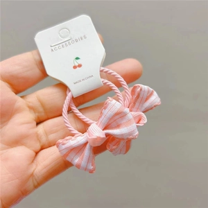 Fiocchi per capelli a scacchi rosa per bambine con elastici su cartoncino bianco