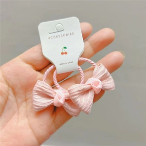 Primo piano di elastici per capelli con fiocchi rosa a pois per bambine su carta