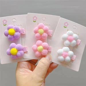 Detailed view of three pairs of plush flower hair clips in purple, pink and white colors