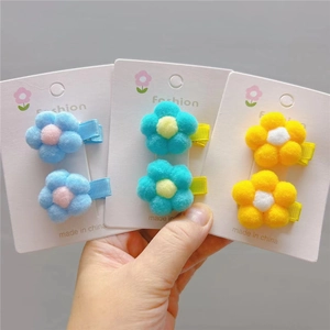 Detailed close-up of colorful plush flower hair clips for girls on display cards