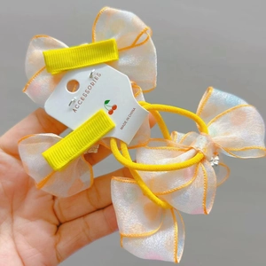 Detail van gele organza strik haarclips en elastische band op een displaykaart