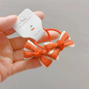 Dettaglio ravvicinato di elastici per capelli con fiocco arancione e bianco
