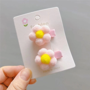 Detail of pink pom-pom flower hair clips for girls with soft plush texture and clips