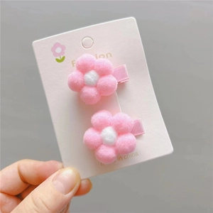 Detail view of plush pink flower hair clips for girls with soft fuzzy petal textures