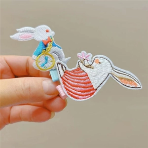 Close-up of cute rabbit embroidered hair clips with detailed hand-stitched floral patterns