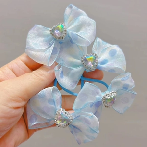 Detail van vier lichtblauwe organza haarstrikjes met hartvormige strass-steentjes