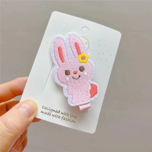 Cute pink embroidered rabbit hair clip with yellow flower and ribbon-wrapped duckbill clip