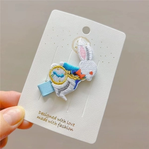 Detailed embroidery of white rabbit with blue vest and pocket watch on a hair clip
