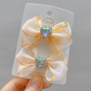 Detail van gele haarstrikken met hartvormige strass op een witte displaykaart