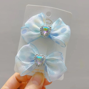 Detailweergave van lichtblauwe stippen haarspelden met strass hartkristallen