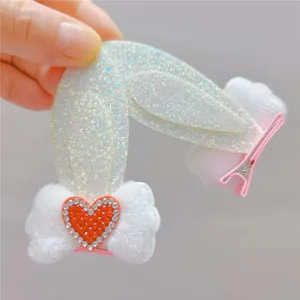 Detail of bunny ear hair clip with silver glitter, white faux fur, and pink metal alligator clip