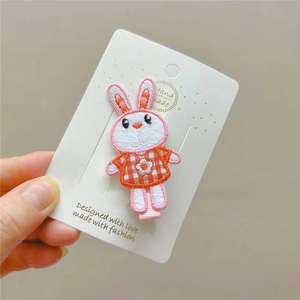 Detail of embroidered rabbit hair clip with fabric texture and handmade floral pattern