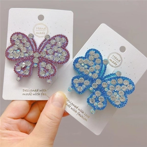 Close-up of sparkling rhinestone butterfly hair clips on handmade display cards