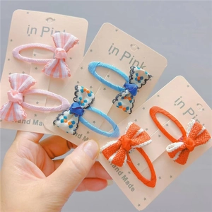 Close-up of handmade fabric bow hair clips in pink stripes and floral patterns