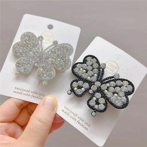Detail of elegant butterfly hair clips featuring sparkling rhinestones in black and white