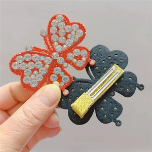Detail of sparkling rhinestone butterfly hair clip with gold sequin fabric backing
