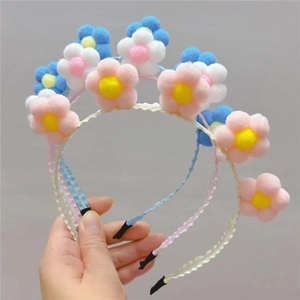 Détail de serre-têtes tournesol en peluche colorée avec pétales pompons tons macaron
