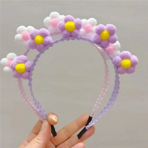 Détail du serre-tête tournesol en peluche avec motif floral 3D en couleurs macaron