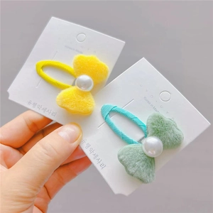 Gros plan de barrettes à cheveux en peluche avec nœuds, perles et ruban de tissu
