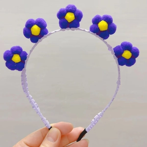 Détails du serre-tête avec fleurs de tournesol en peluche violette et centres jaunes