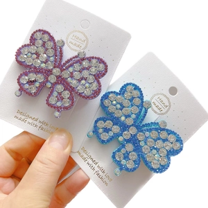 Sparkling butterfly hair clips set with rhinestones in purple and blue on display card