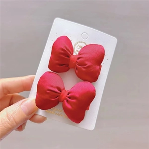 Set of two red satin bow hair clips on display card with a pastoral lolita design style