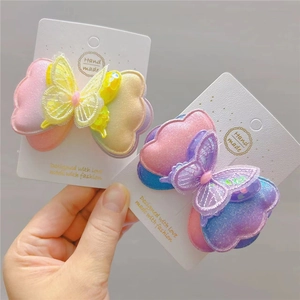 Détail des pinces à cheveux papillon faites main avec dentelle dégradée et paillettes brillantes