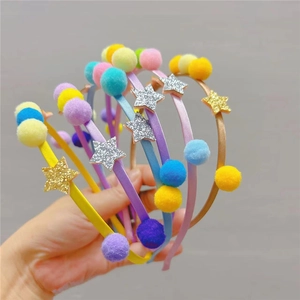 Détail de serre-têtes colorés avec pompons doux et étoiles à paillettes pour enfants