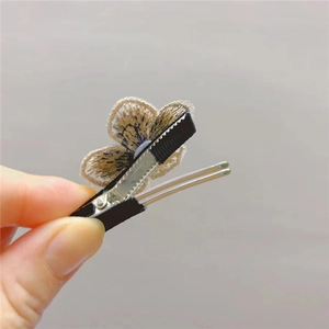 Detail showing high-quality embroidery floral hair clip with crystal accents and grip
