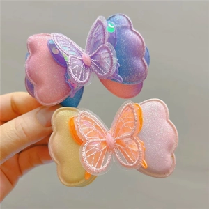 Détail de barrettes papillon dégradées avec paillettes scintillantes et broderies