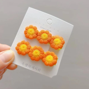 Detail of sunflower crochet hair clips for girls featuring yellow and orange knit petals