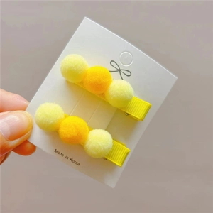 Set of two yellow candy-colored plush pom-pom hair clips for girls in a sweet style