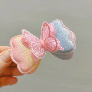 Gros plan d'une pince à cheveux papillon dégradé rose et bleu avec paillettes fines