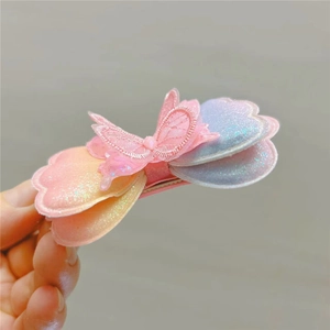 Gros plan détaillé d'une pince à cheveux papillon dégradé rose et violet avec paillettes