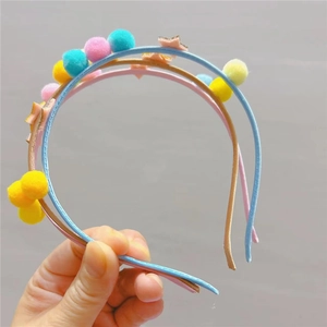 Détail de serre-têtes en tissu avec pompons colorés et décorations d'étoiles