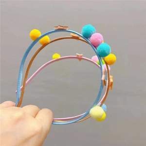 Gros plan de trois serre-têtes pour enfants avec pompons et étoiles scintillantes