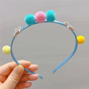 Serre-tête enfant avec pompons colorés et étoiles pailletées en tissu bleu pastel