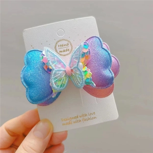 Pince à cheveux papillon faite main avec paillettes bleues et broderie sur carton blanc