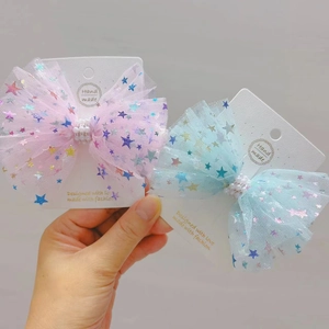 Détail de barrettes nœuds en tulle rose et bleu avec perles sur carte de présentation