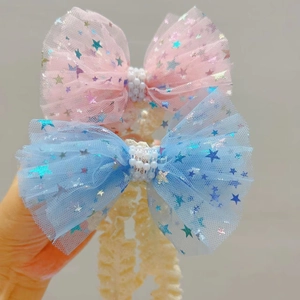 Detail eines Baby-Haarbands aus Netz mit glitzernden Sternen und eleganten Perlen