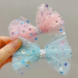 Détail de barrettes à nœuds en résille avec paillettes étoiles et perles centrales