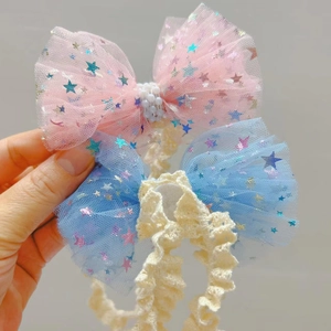 Detail von rosa und blauen Netzschleifen-Stirnbändern mit Sternen und Perlen für Babys