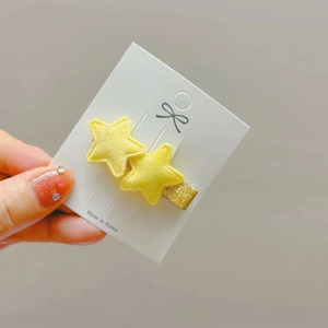 Yellow glitter double star hair clip with gold sequins on a display card from Korea
