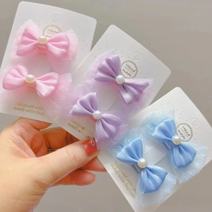 Détail de barrettes à nœuds faites à la main avec perles et tulle sur carte de support