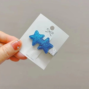 Detailed view of blue glitter star hair clips on display card with silver metal base