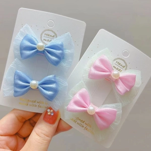 Détail de pinces à cheveux avec nœuds en perles, rubans de satin et organza