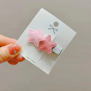 Detail of glittered star hair clips with double pink sequin layers on card holder